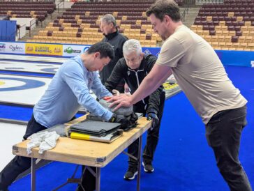 From the left, Jason Lee, Mark Callan and Cody Hall work to paper one of the curling stones at the 2026 World Men's Curling Championship in Ogden, Utah, on Tuesday, March 31, 2026. (Ryan Olson, Standard-Examiner)